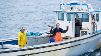 Two lobster fisherman aboard a vessel